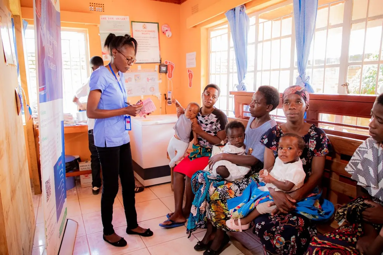 A nurse with mothers and babies in the clinic’s under-five room