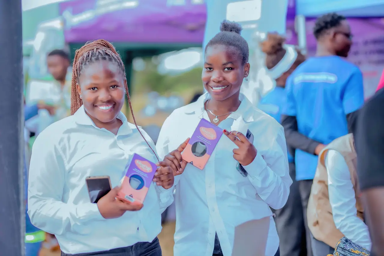 Two young women smiling as they hold up their new menstrual cups